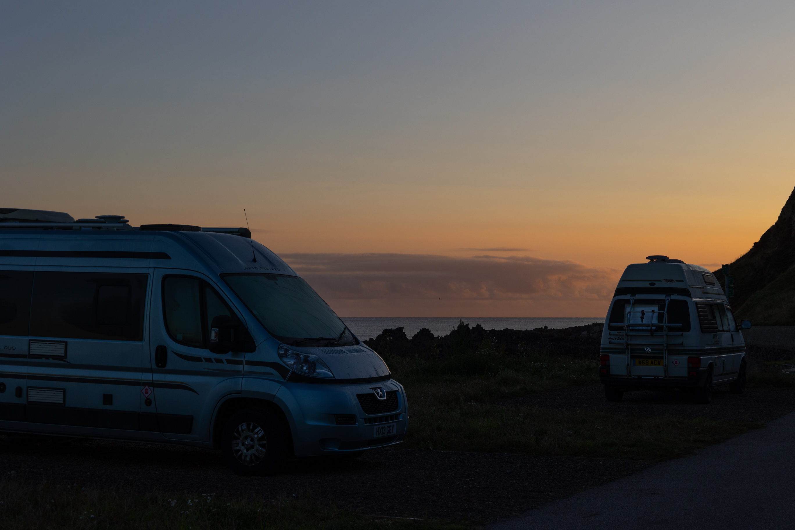 Campervans im Sonnenaufgang in Schottland