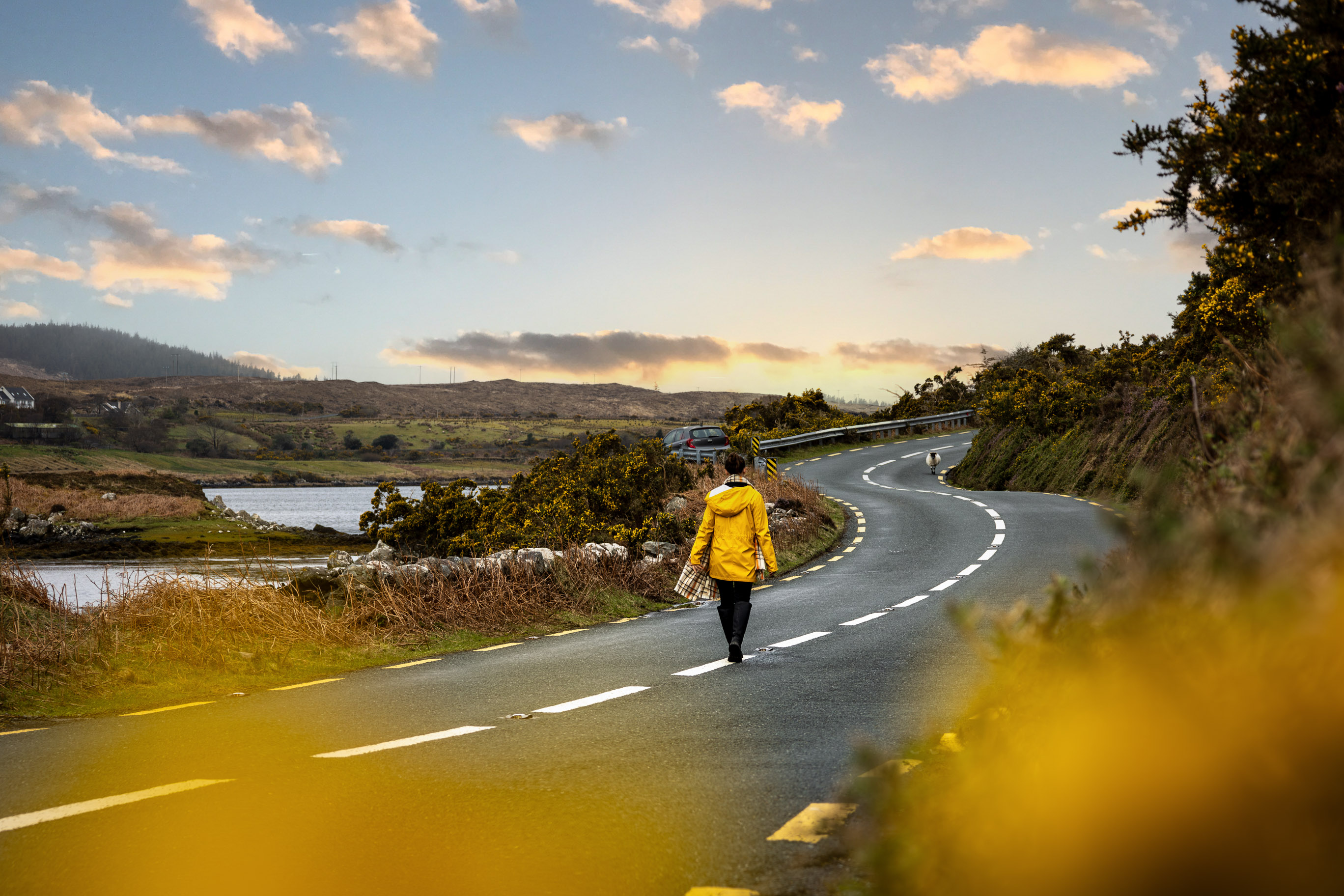 junge Frau auf einer Landstraße in Irland