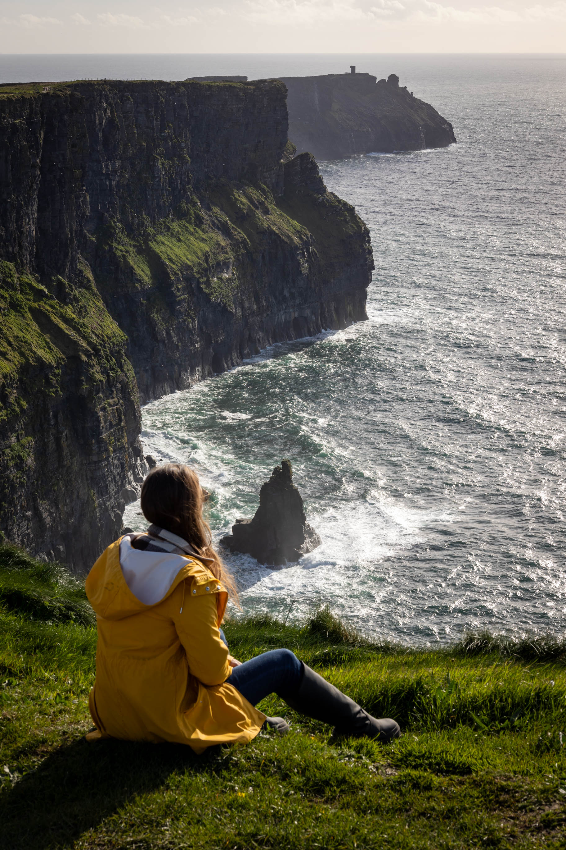 junge Frau blickt auf die Cliffs of Moher in Irland